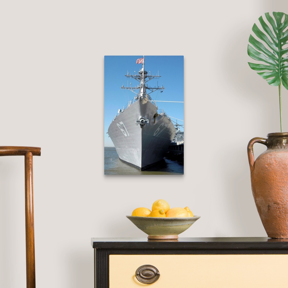 A traditional room featuring The guided missile destroyer USS Cole sits moored to a pier