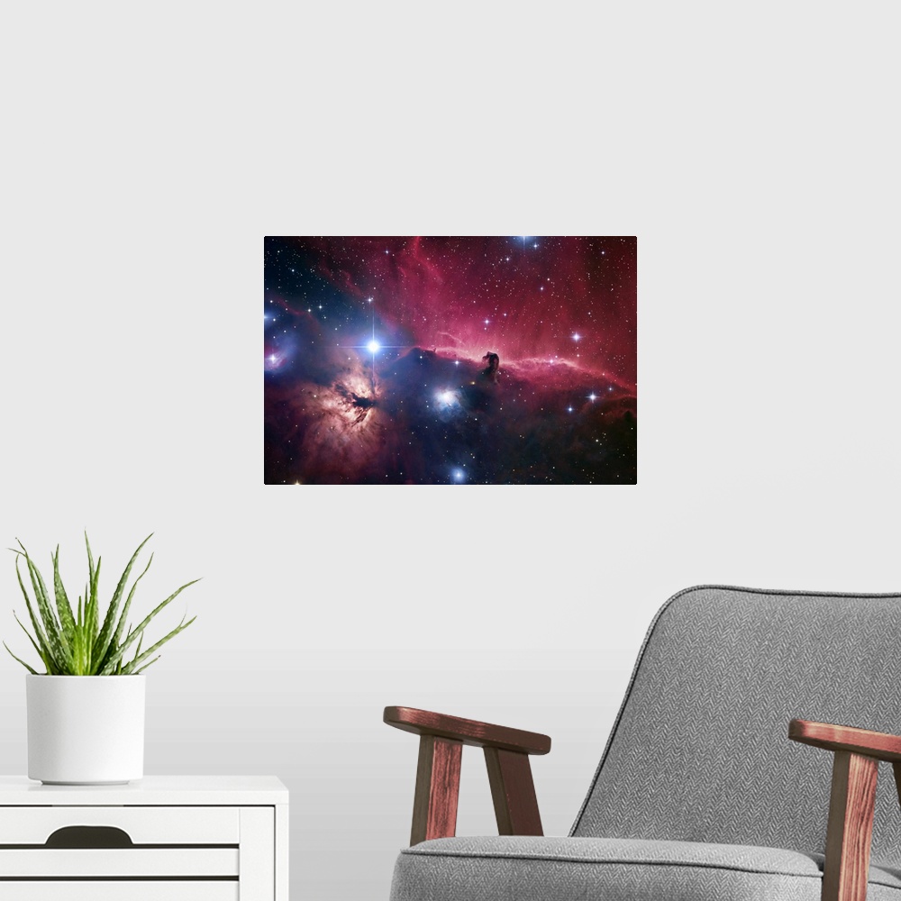 A modern room featuring Large photograph displays an open part of space filled with stars and focusing on aodark cloud of...