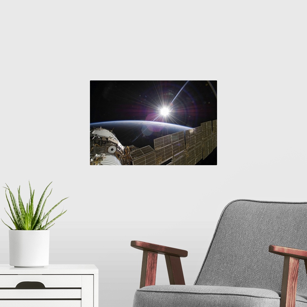 A modern room featuring The International Space Station backdropped by the bright Sun over Earths horizon