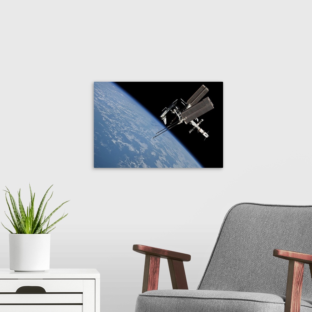 A modern room featuring May 23, 2011 - The International Space Station and docked Space Shuttle Endeavour, backdropped by...