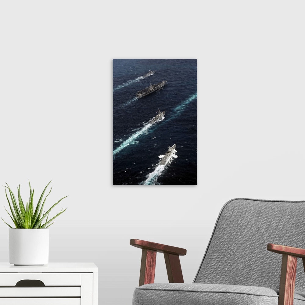 A modern room featuring The John C. Stennis Carrier Strike Group are underway in formation with naval vessels from the Re...