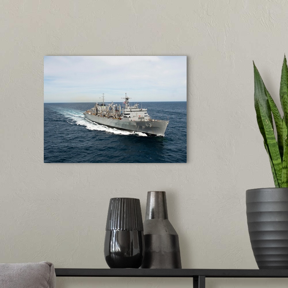 A modern room featuring The Military Sealift Command fast combat support ship USNS Supply.