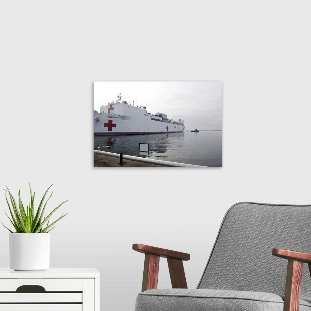 A modern room featuring The Military Sealift Command hospital ship USNS Comfort pulls away from Canton Pier