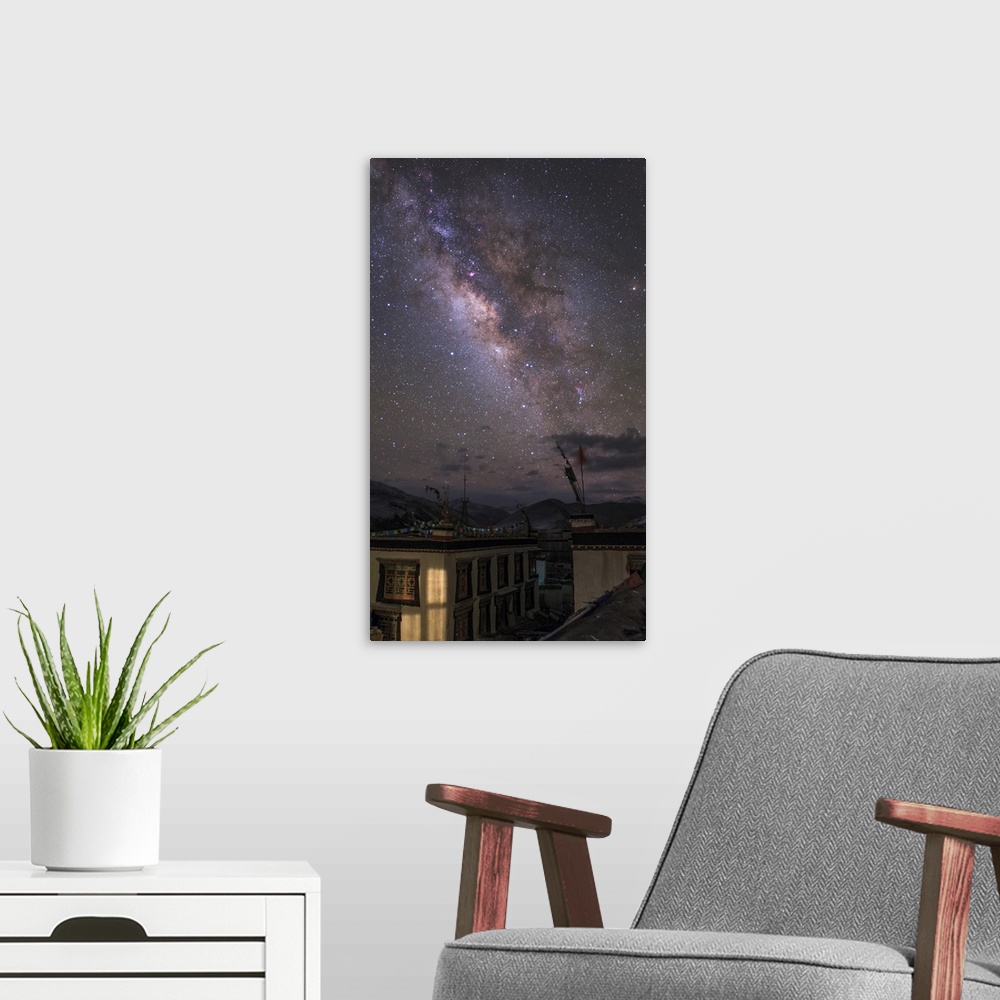 A modern room featuring A spectacular view of the Milky Way photographed over a small village in Tibet, China