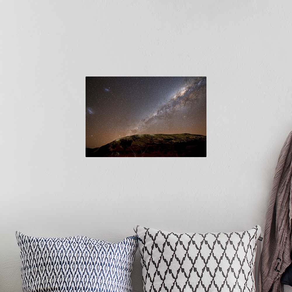 A bohemian room featuring The Milky Way and its satellite galaxies the Magellanic Clouds rising above the hills of Azul, Ar...
