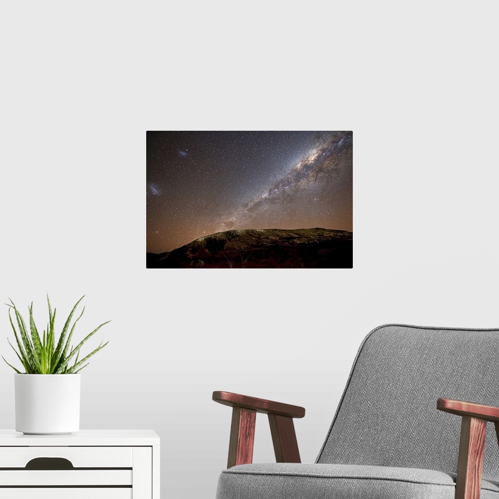 A modern room featuring The Milky Way and its satellite galaxies the Magellanic Clouds rising above the hills of Azul, Ar...