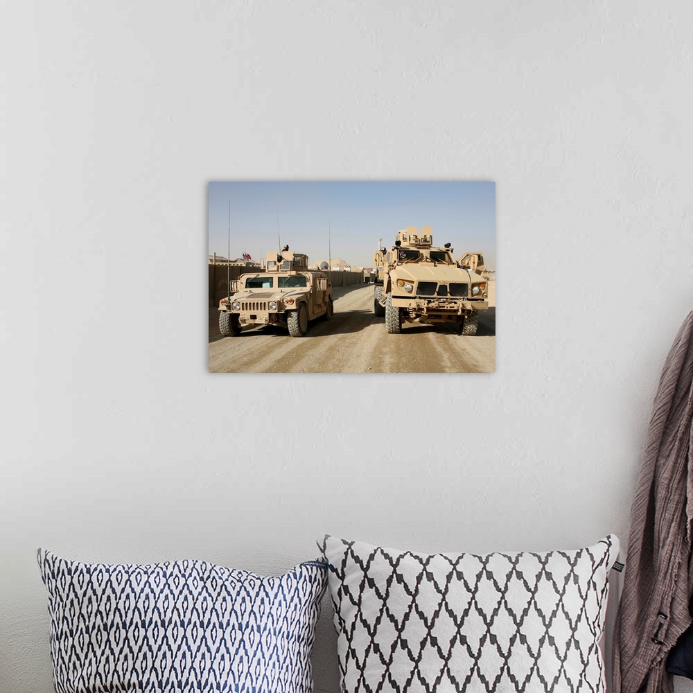 A bohemian room featuring The Mine Resistant Ambush Protected All Terrain Vehicle and its predecessor, the humvee.