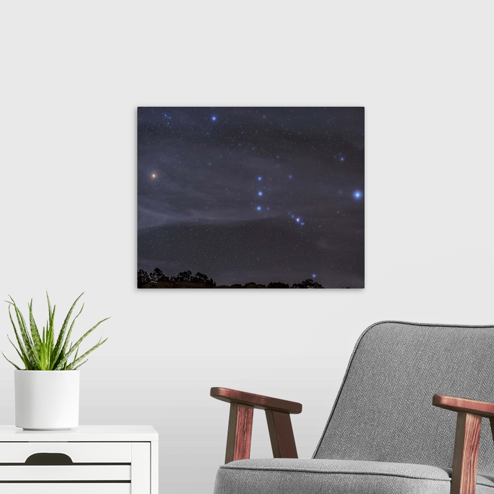 A modern room featuring The Orion constellation rises over a hill through high thin clouds near Black Mesa, Oklahoma.