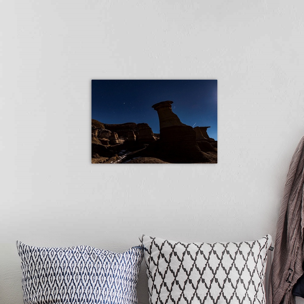 A bohemian room featuring The Pleiades appearing from behind the Hoodoos in silhouette.