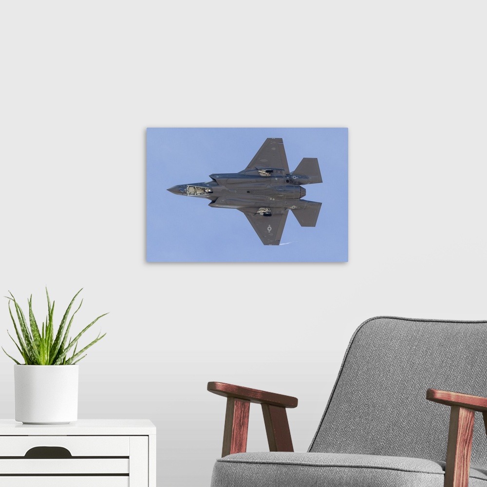 A modern room featuring The underside of a U.S. Air Force F-35A Lightning II as it turns on to final approach at Nellis A...
