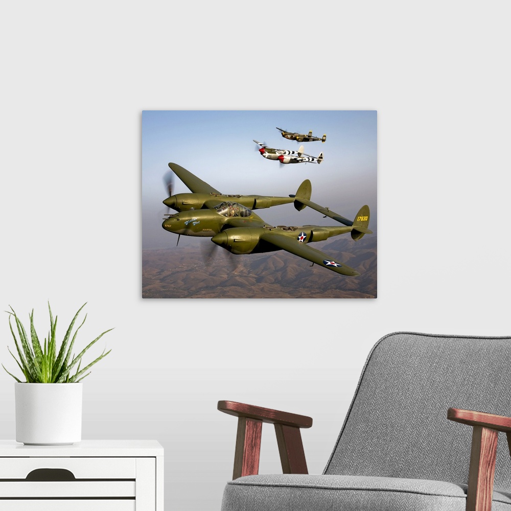 A modern room featuring Three vintage military aircrafts are photographed in the sky as they fly high over mountainous te...