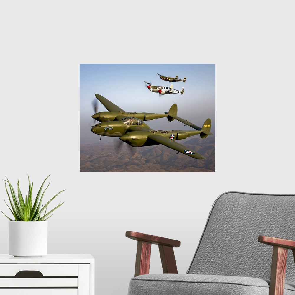 A modern room featuring Three vintage military aircrafts are photographed in the sky as they fly high over mountainous te...