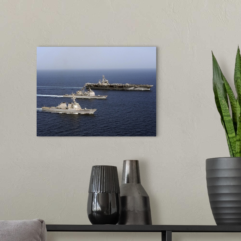 A modern room featuring Three U.S. Navy ships sail in formation in the Arabian Sea.