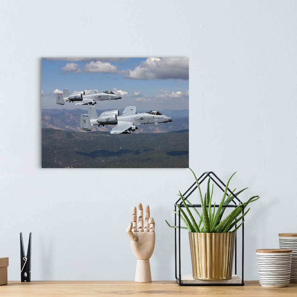 A bohemian room featuring Two A-10 Thunderbolt's from the 124th Fighter Wing's 190th Fighter Squadron fly over the mountain...
