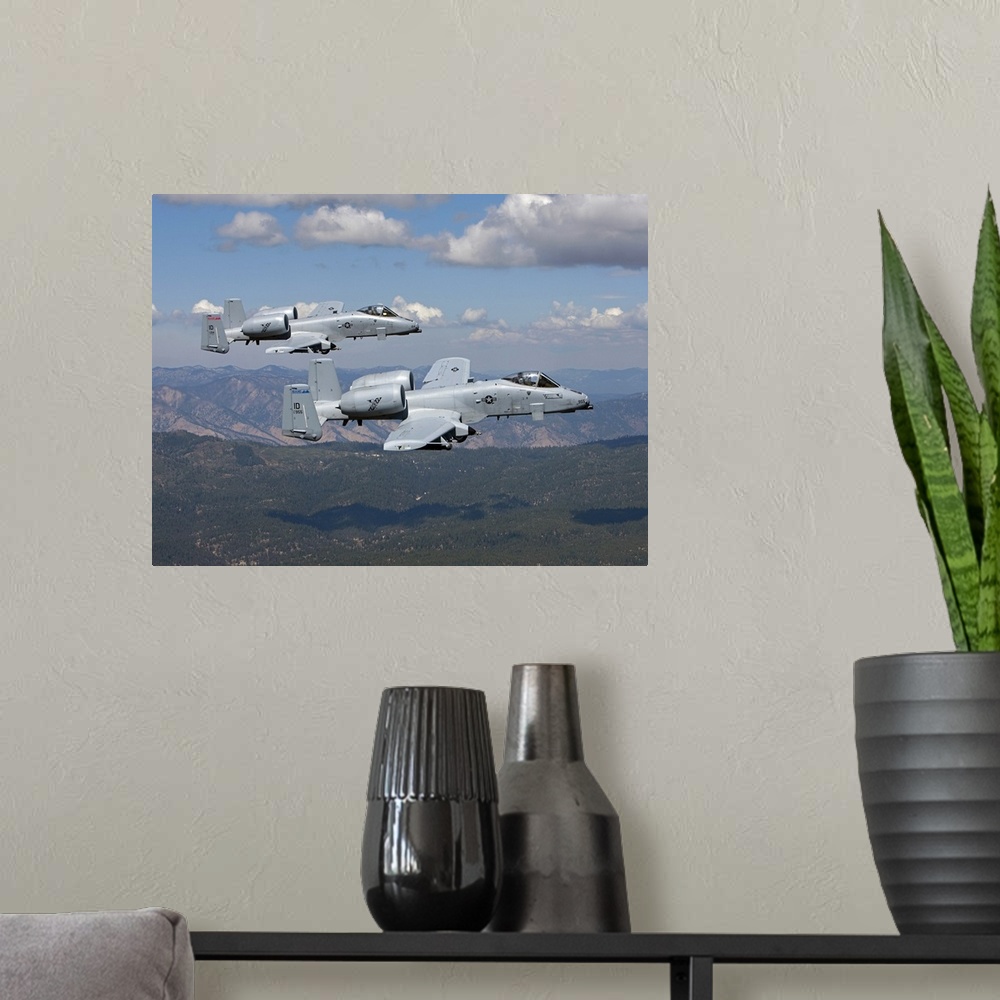 A modern room featuring Two A-10 Thunderbolt's from the 124th Fighter Wing's 190th Fighter Squadron fly over the mountain...