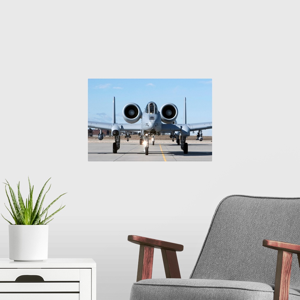 A modern room featuring Two A-10 Thunderbolt's from the 190th Fighter Squadron taxi to the runway on a training mission o...