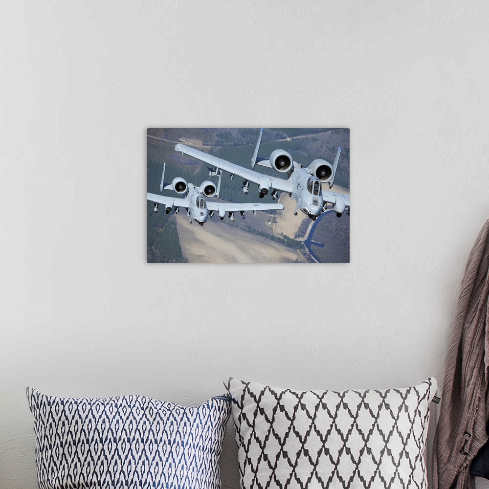 A bohemian room featuring Two A-10C Thunderbolt II aircraft fly in formation.