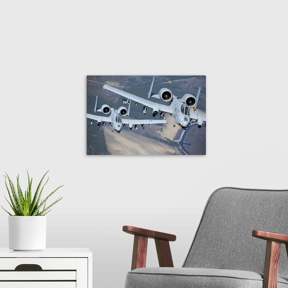 A modern room featuring Two A-10C Thunderbolt II aircraft fly in formation.