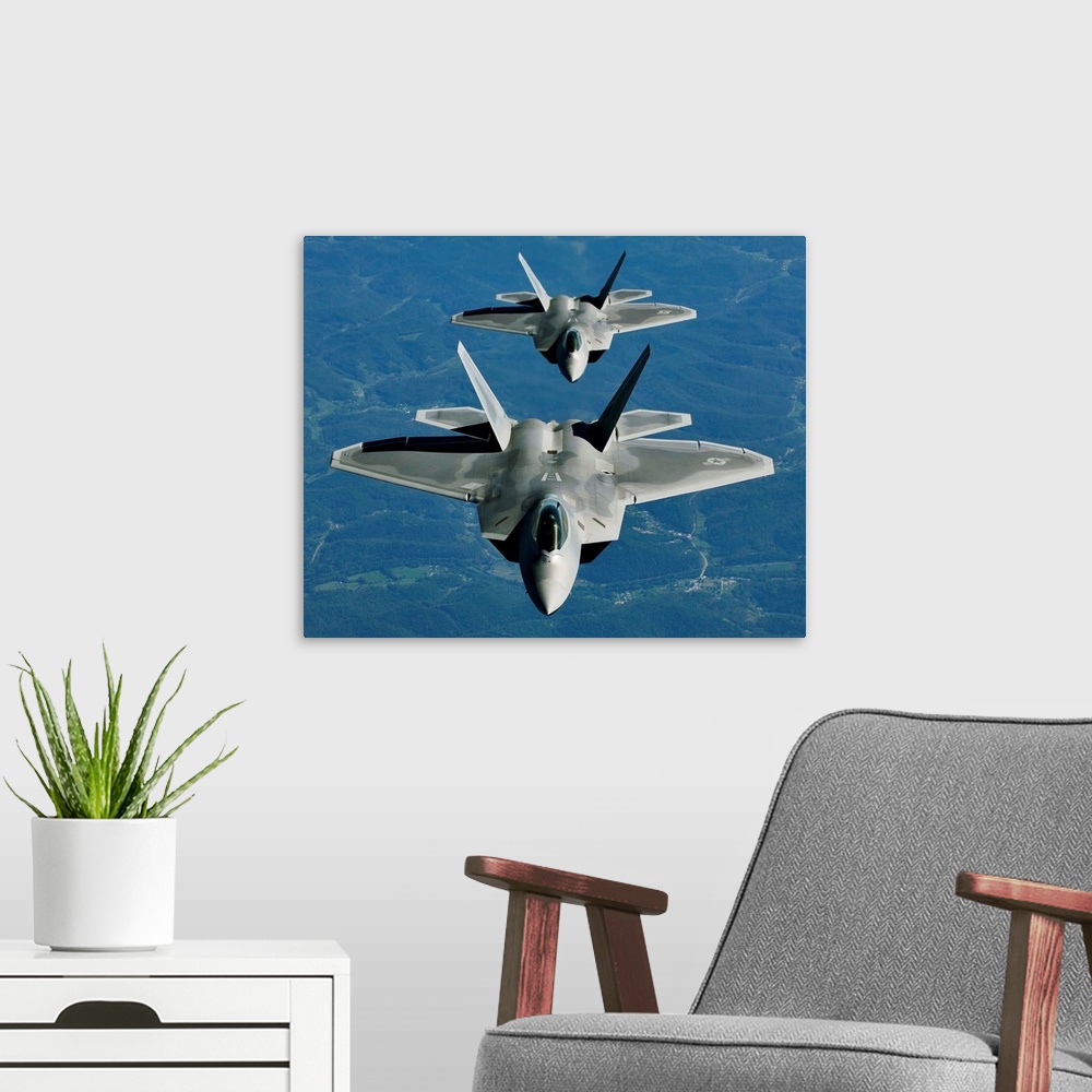 A modern room featuring Two F-15's fly in formation behind a KC-10 Extender.