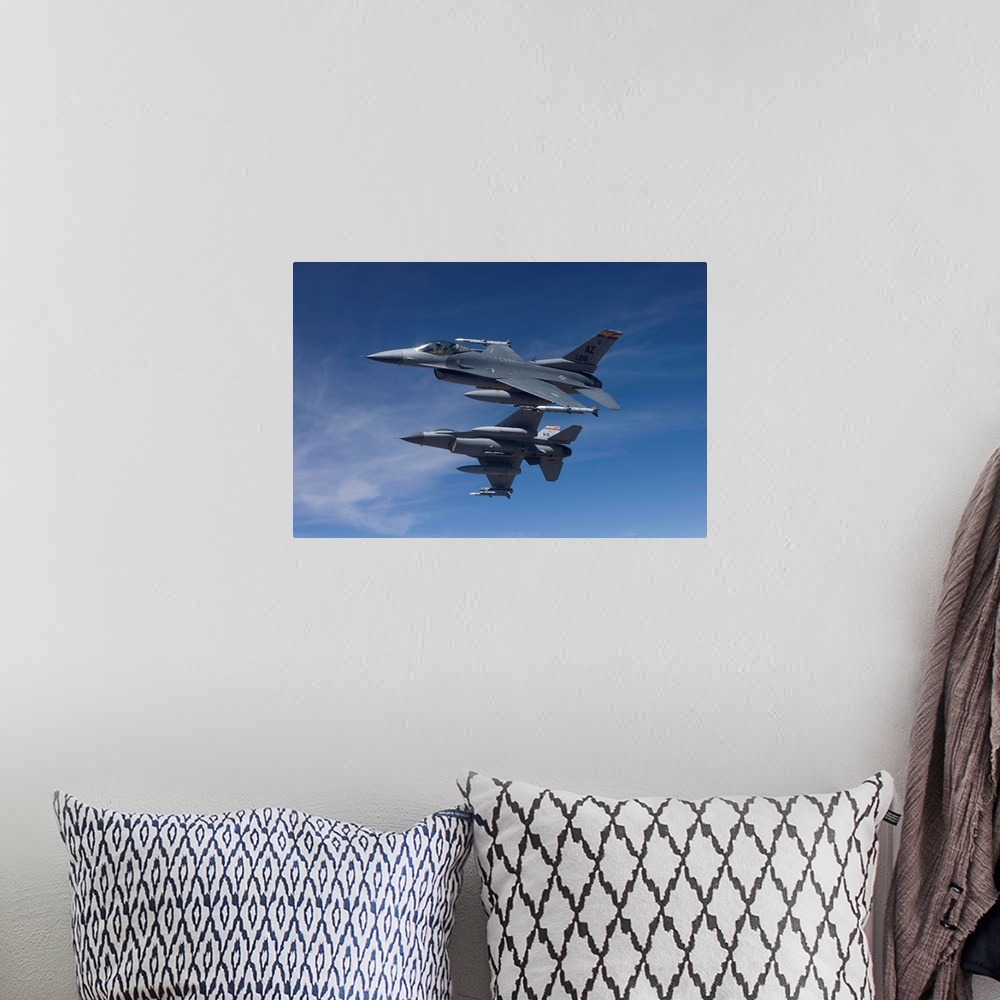 A bohemian room featuring Two F-16's from the 162nd Fighter Wing manuever on an air-to-air training mission.