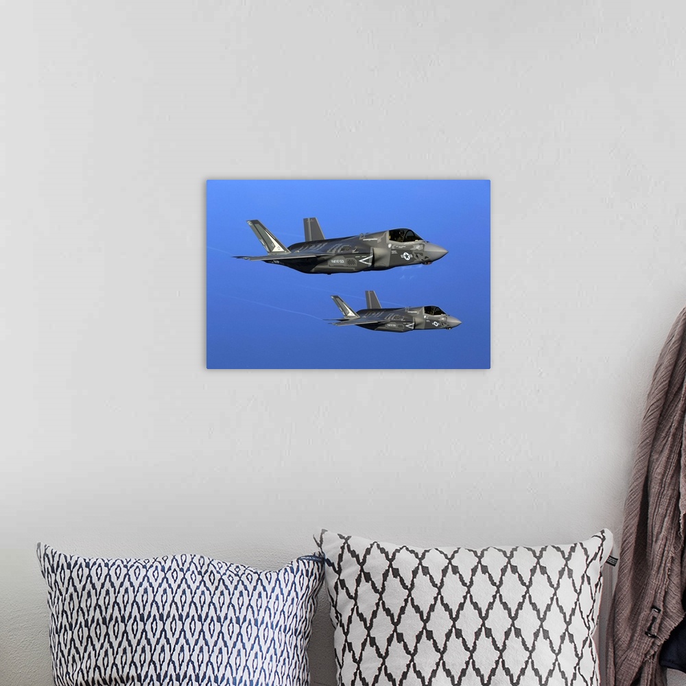 A bohemian room featuring Two F-35B joint strike fighter jets conduct aerial maneuvers.