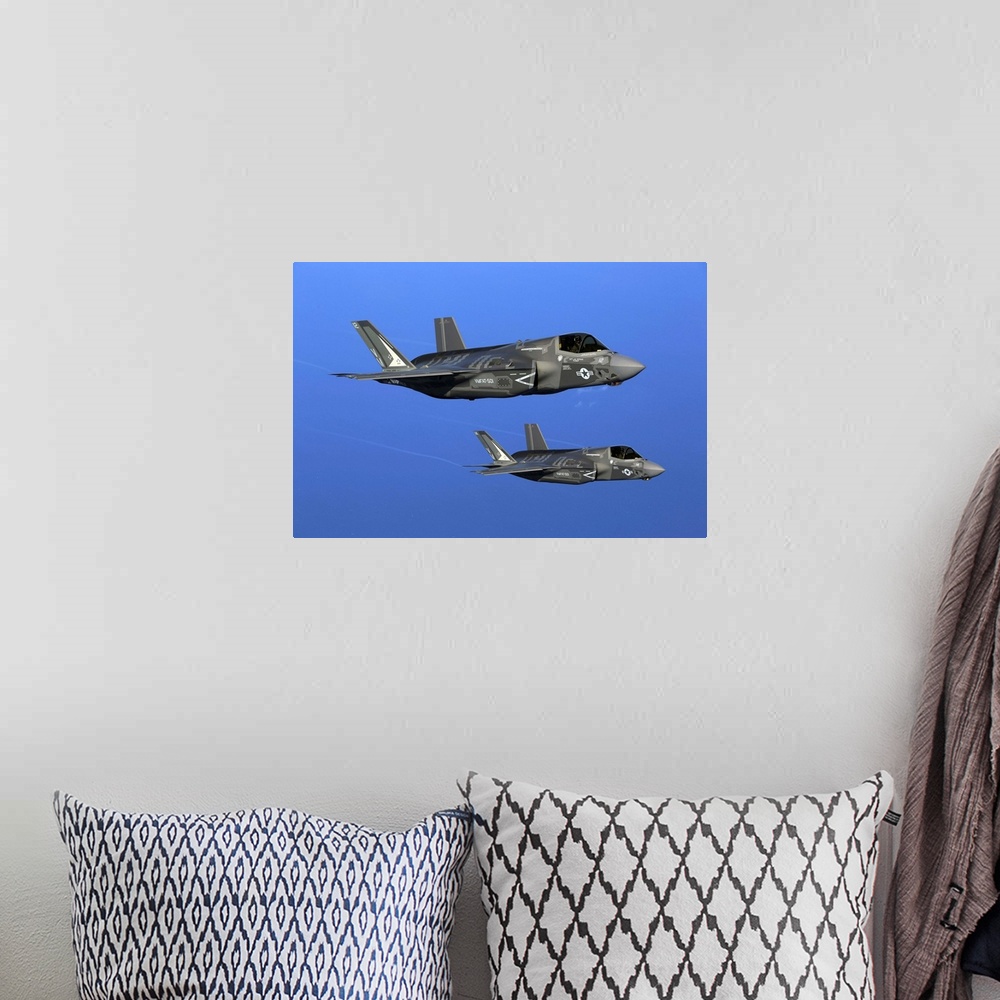 A bohemian room featuring Two F-35B joint strike fighter jets conduct aerial maneuvers.