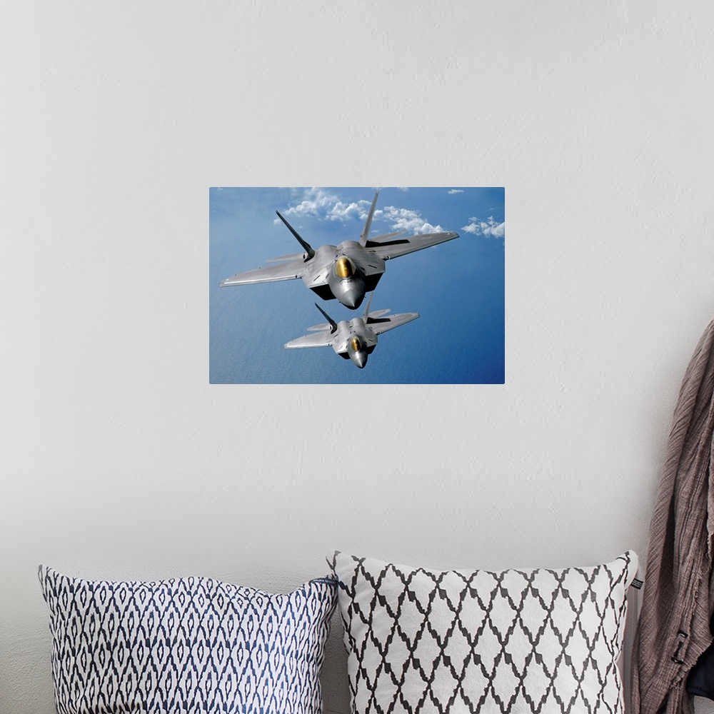 A bohemian room featuring Large, landscape photograph of two F22 Raptors flying high in the sky above the blue waters of th...