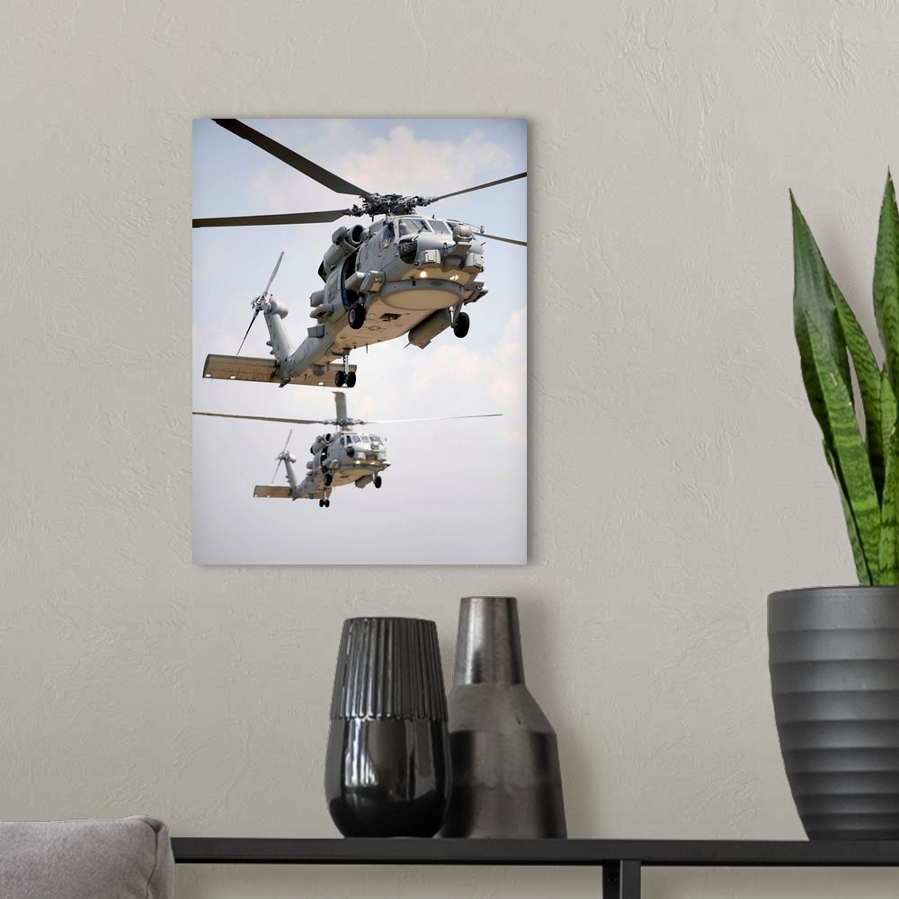 A modern room featuring Two multi-mission MH-60R Sea Hawk helicopters fly in tandem.