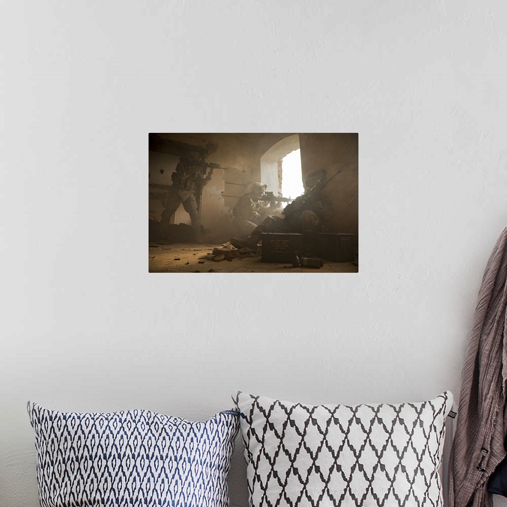 A bohemian room featuring This is a horizontal photograph of three soldiers in a damaged interior peering out a window.