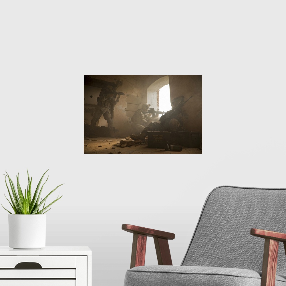 A modern room featuring This is a horizontal photograph of three soldiers in a damaged interior peering out a window.