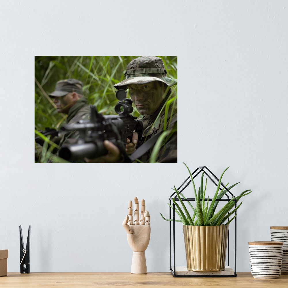A bohemian room featuring U.S. Special Forces soldiers patrol through tall grass during combat.