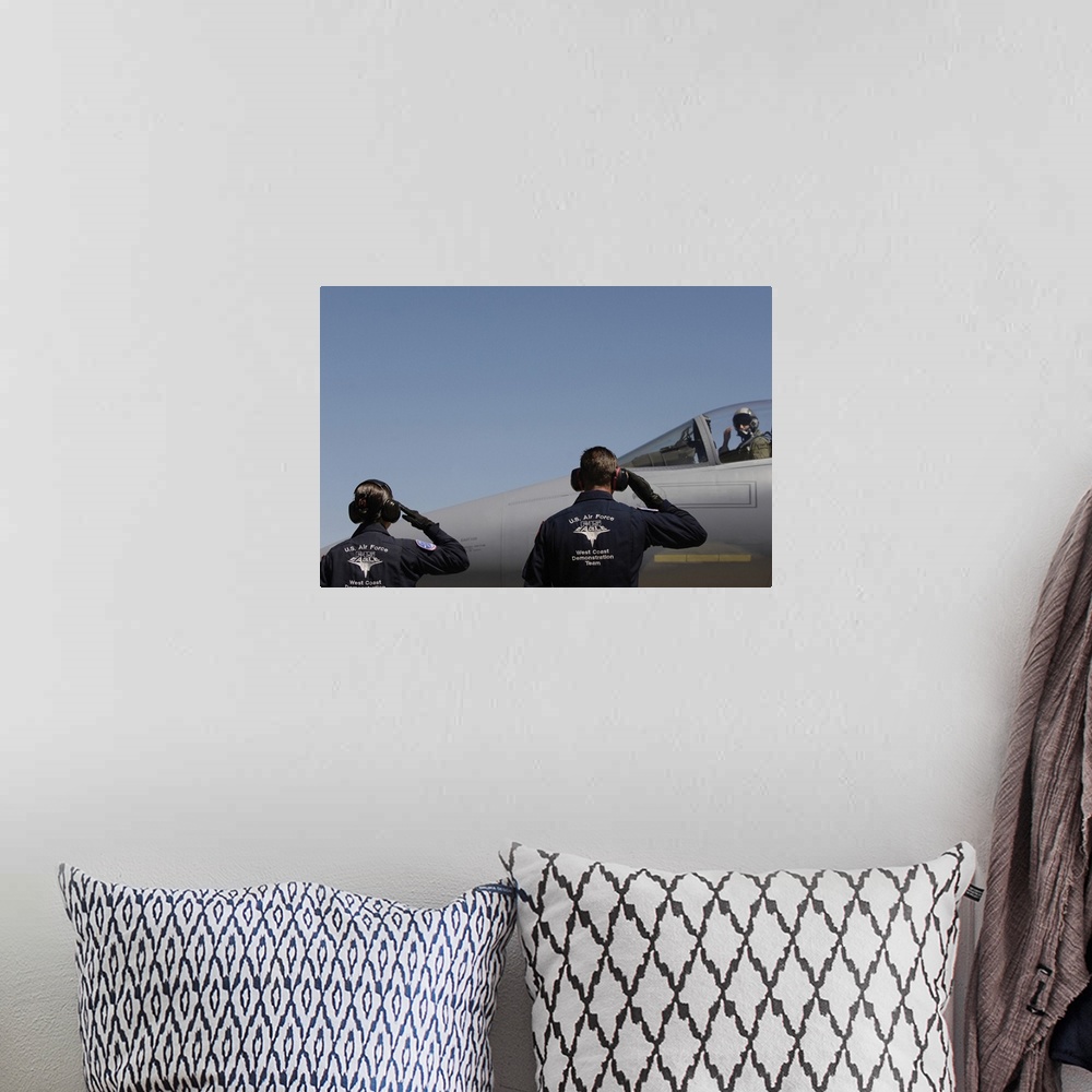 A bohemian room featuring US Air Force Airmen salute the Captain of an aircraft