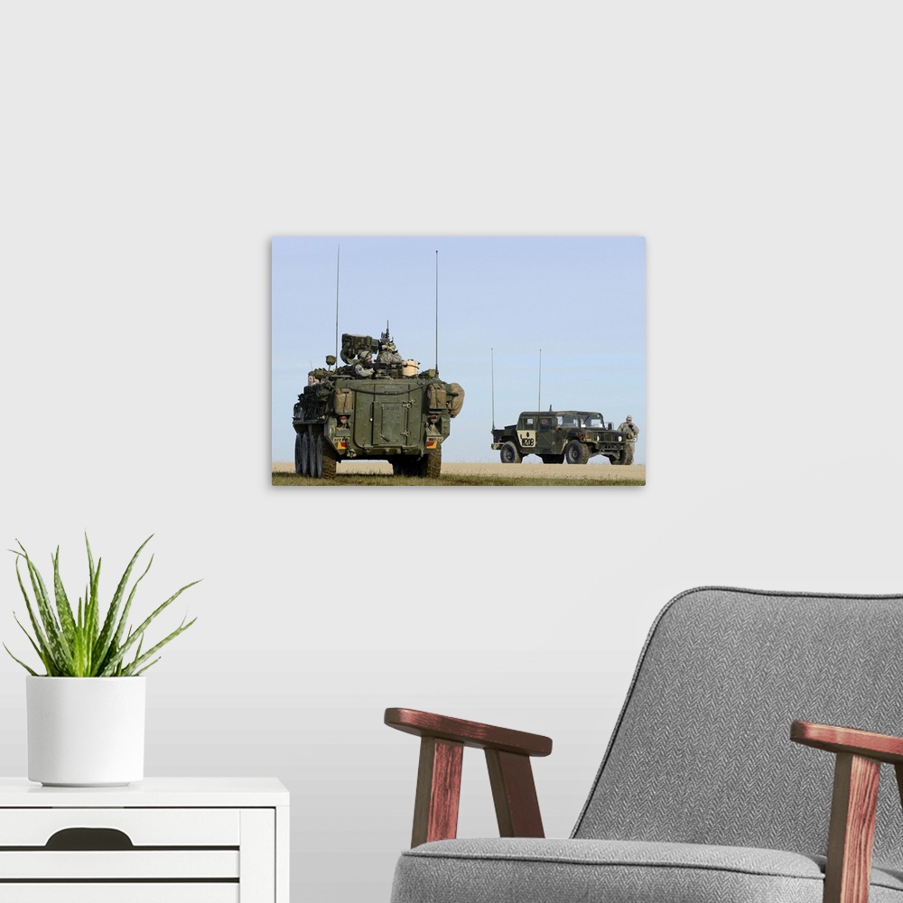 A modern room featuring U.S. Army Europe Stryker soldiers aim at targets at the Grafenwoehr Training Area.