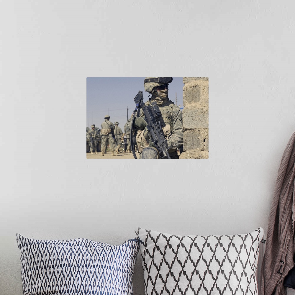 A bohemian room featuring US Army Soldier armed with a MK48 light machine gun