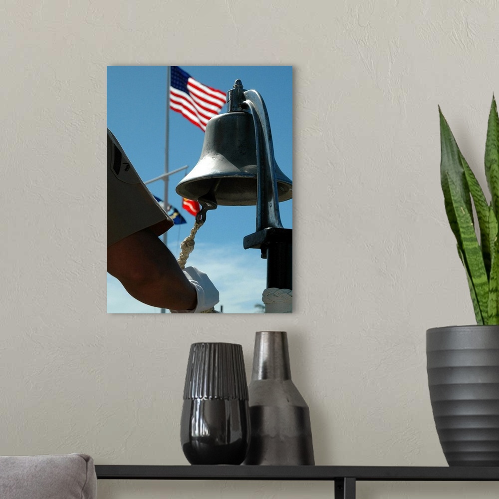 A modern room featuring US Marine sounds a bell honoring fallen Marines during a ceremony