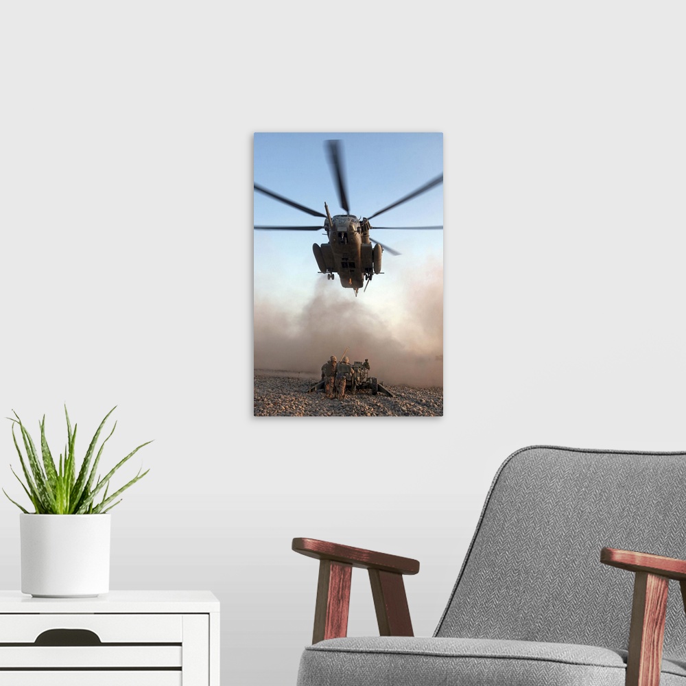 A modern room featuring US Marines attach an M777A2 Lightweight Howitzer to a CH53E Super Stallion helicopter