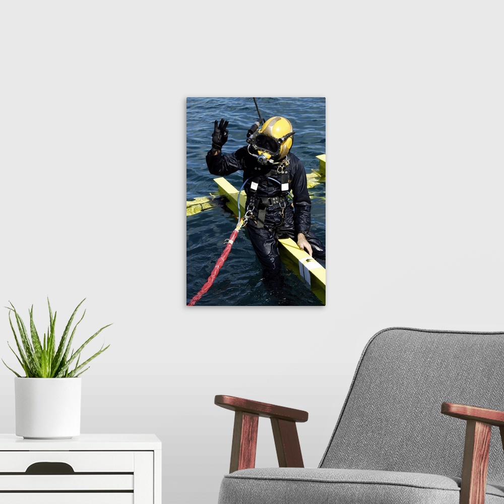 A modern room featuring February 1, 2007 - U.S. Navy Diver signals an OK sign to the dive supervisor on a dive station of...