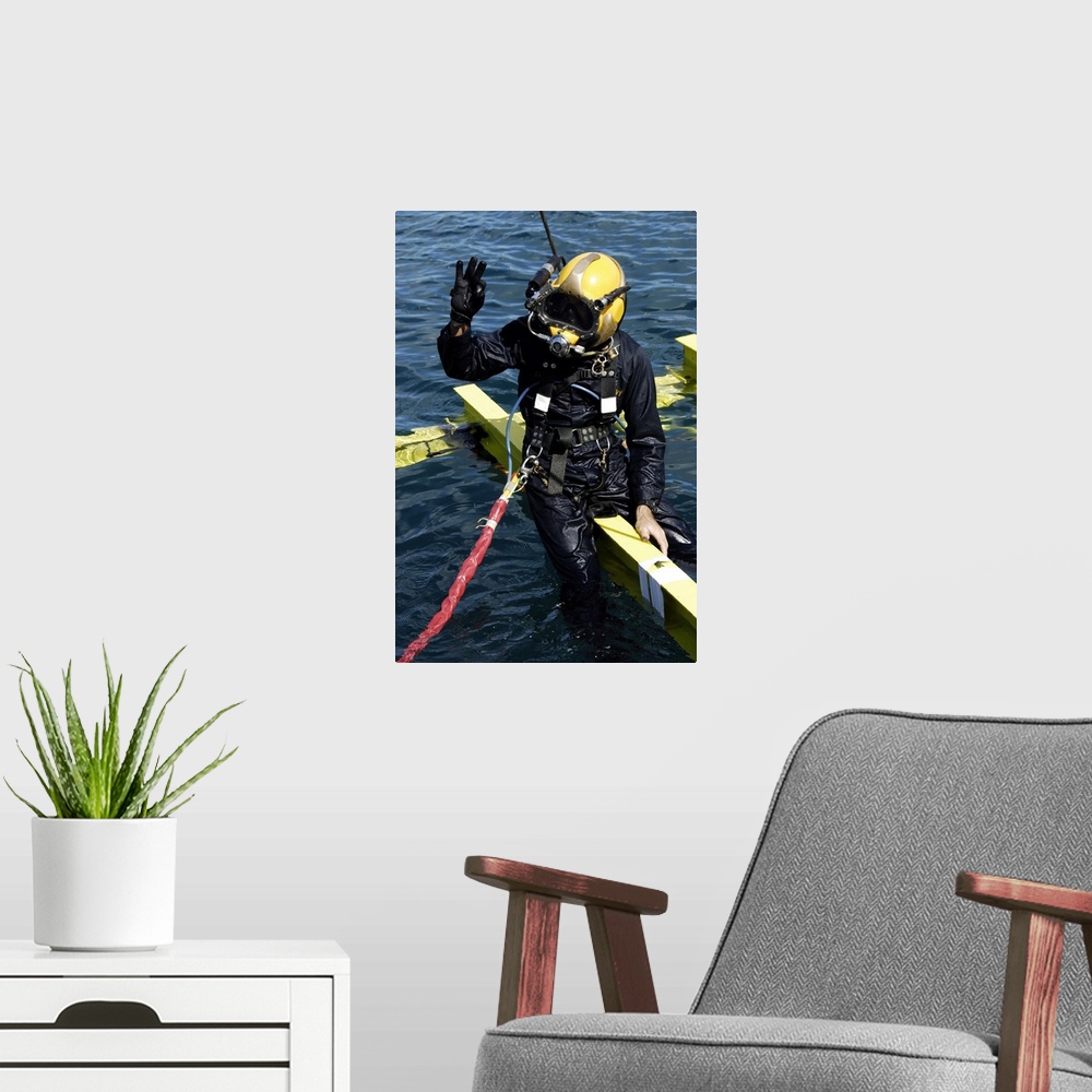A modern room featuring February 1, 2007 - U.S. Navy Diver signals an OK sign to the dive supervisor on a dive station of...