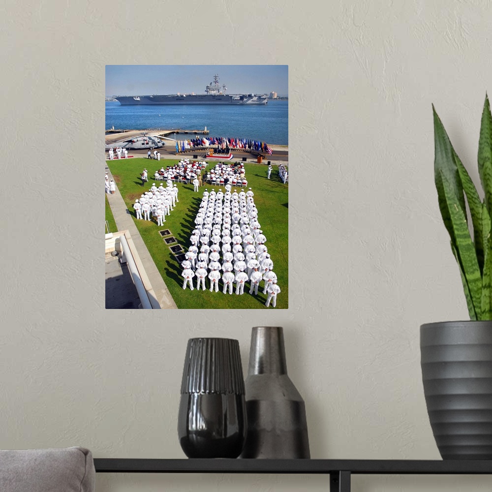 A modern room featuring US Navy Sailors attend an establishment ceremony