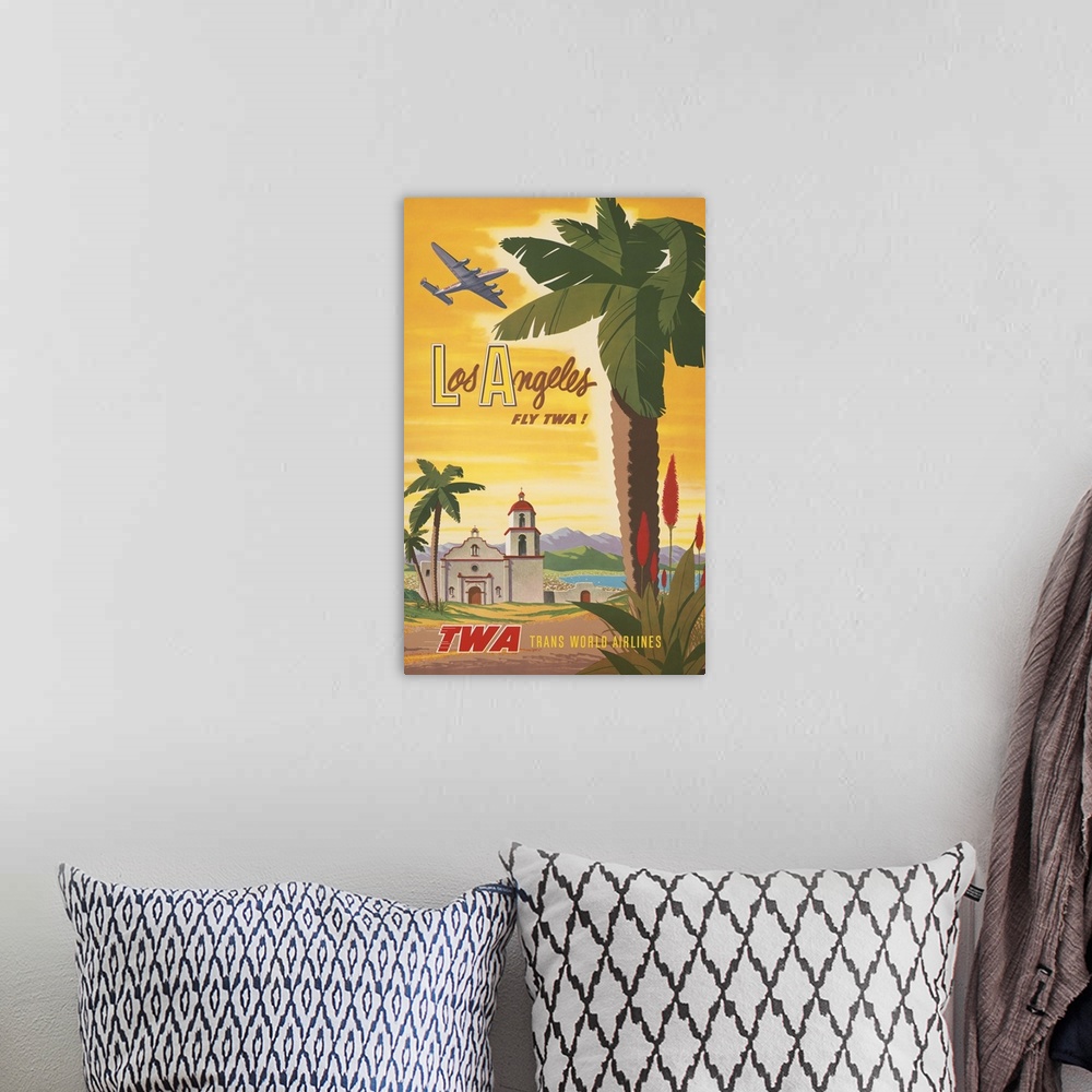 A bohemian room featuring Vintage travel poster, Fly TWA to Los Angeles, shows airplane flying over a Spanish mission churc...