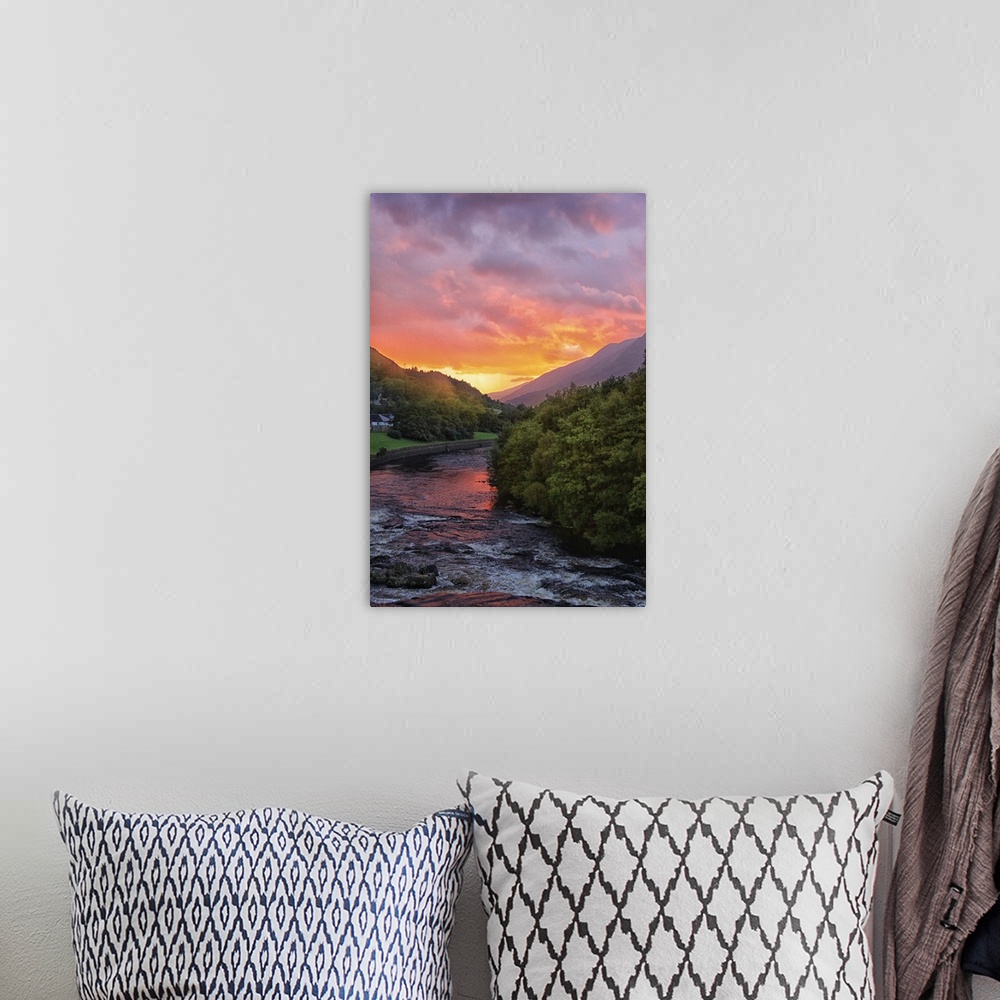 A bohemian room featuring Sunset illuminating the clouds over a river in Scotland.