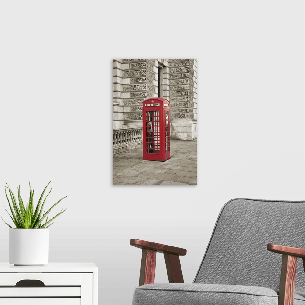 A modern room featuring Photo of a phone booth colored red in London, England.