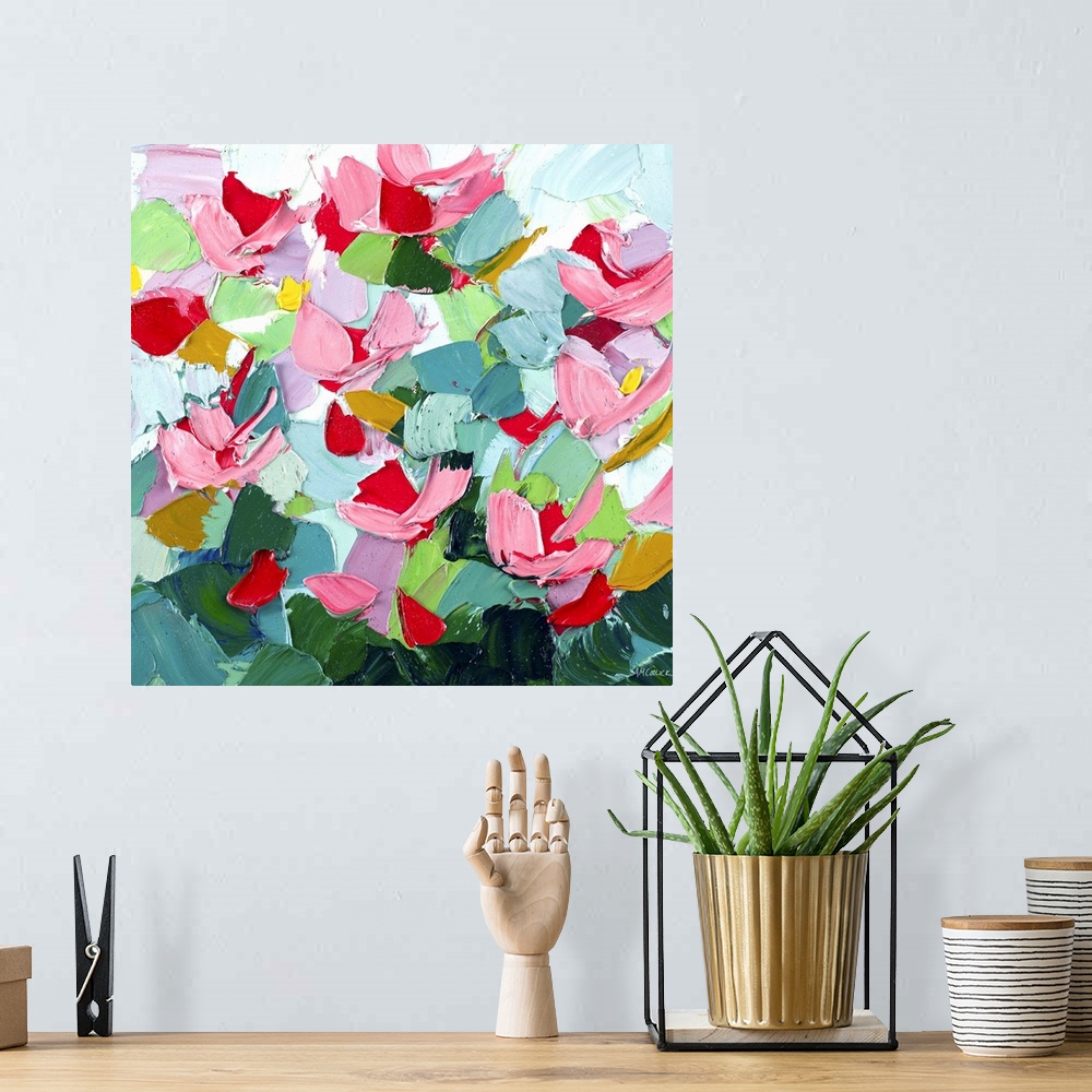 A bohemian room featuring Brightly colored abstract artwork with pink flowers on green.