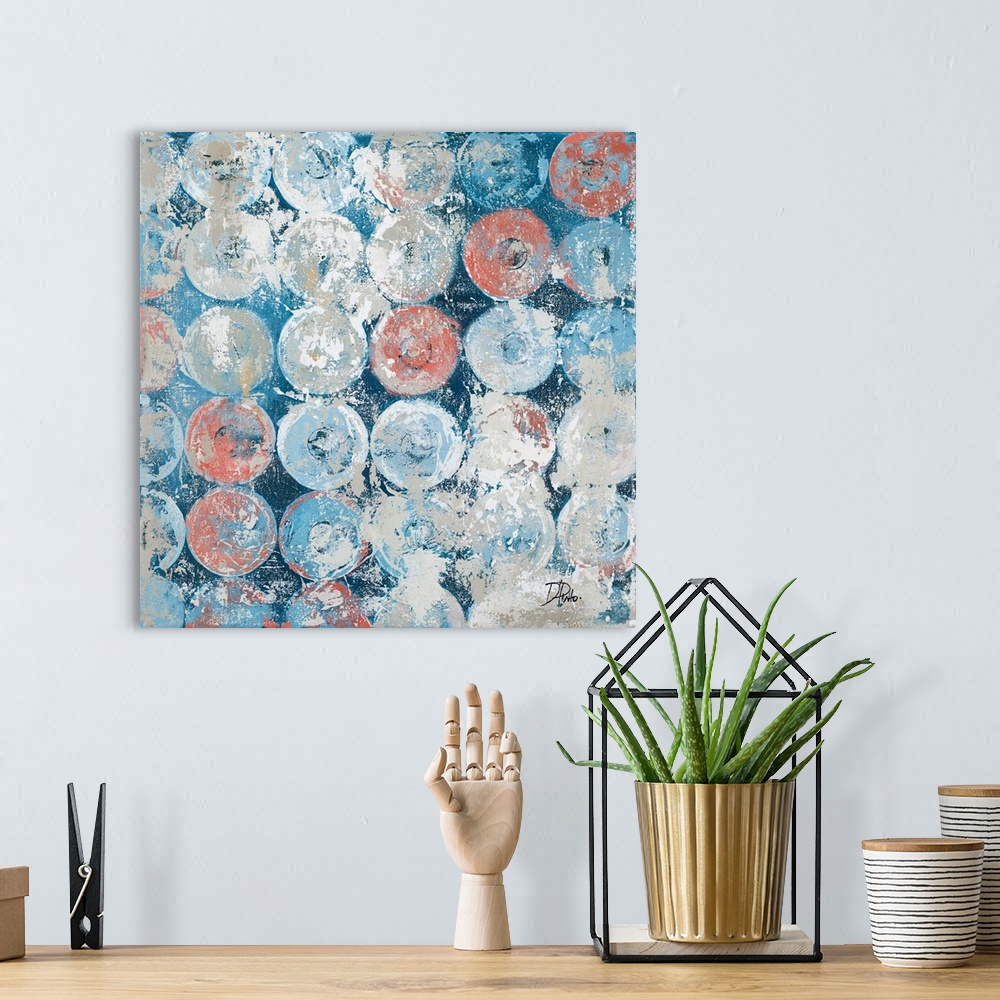 A bohemian room featuring A square abstract painting with an antique feel and blue, gray, and salmon colored circles.
