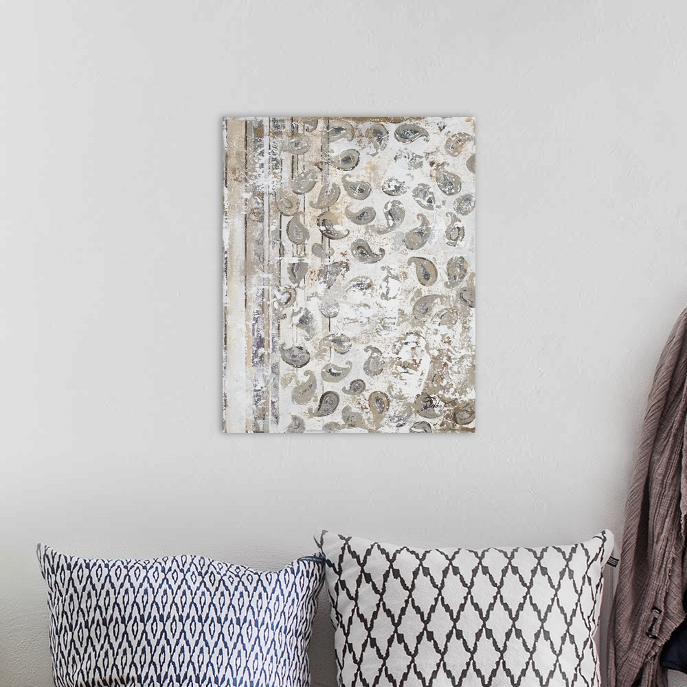 A bohemian room featuring A vertical abstract painting with an antique paisley pattern in gray, tan, and white hues.