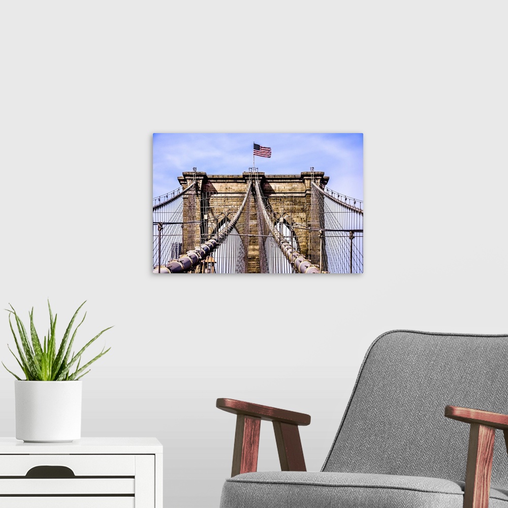 A modern room featuring An architectural photograph of the Brooklyn Bridge with the American flag on top.