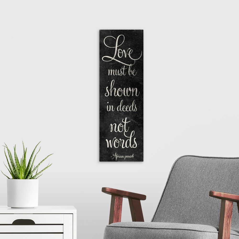 A modern room featuring "Love must be shown in deeds not words" in script writing on a chalkboard style panel.