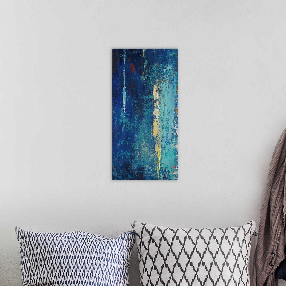 A bohemian room featuring A contemporary abstract painting with dark blues mixed with light blues, yellows and red.