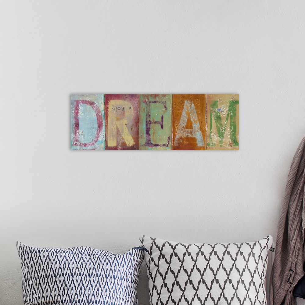 A bohemian room featuring Horizontal typographic artwork of distressed painted letters spelling out an inspirational word.