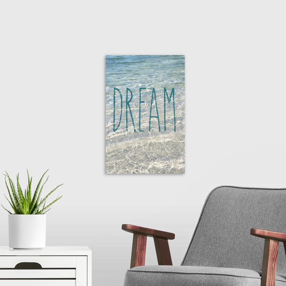 A modern room featuring "Dream" written in blue on top of a photograph of crystal clear ocean water.